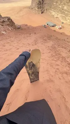 a person holding a skateboard in the desert at Alkaram luxury camp in Wadi Rum