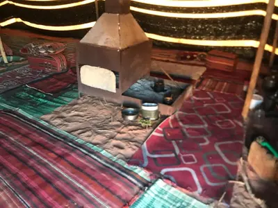 a room with a bed with a stove and a blanket at Ragheb Al-Zawaida in Disah