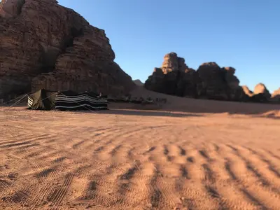 a campsite in the desert with rocks in the background at Ragheb Al-Zawaida in Disah