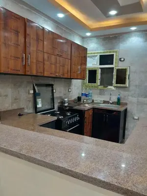 a kitchen with wooden cabinets and a black stove at Aqaba Drought inn in Aqaba