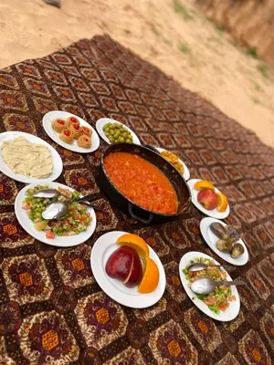 a table topped with plates of food and a pot of food at Bedouin house in Wadi Rum