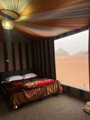 a bedroom with a bed with a view of the desert at مخيم وهج رم in Disah