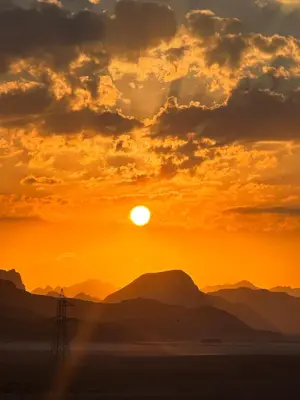 a sunset in the desert with mountains in the background at Rum drone tours in Aqaba