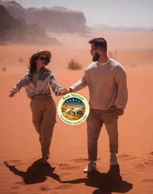 a man and a woman holding a frisbee in the desert at RUM MARTIAN TENT BUBBLES lUXURY CAMP in Wadi Rum