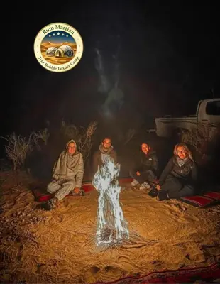 a group of people sitting around a fire at RUM MARTIAN TENT BUBBLES lUXURY CAMP in Wadi Rum