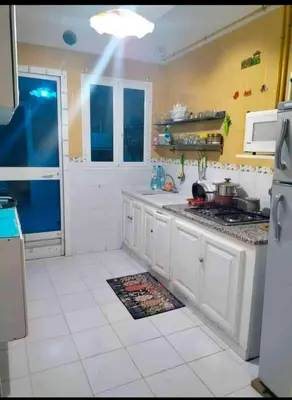 a kitchen with white cabinets and a stove top oven at Loard House in Az Zarqa