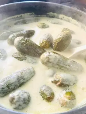 a pan filled with food with potatoes and gravy at Board apartment in Irbid