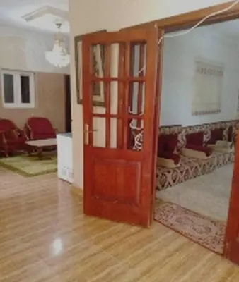 an open door to a living room with a couch at Board apartment in Irbid