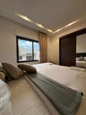 a large bedroom with two beds and a window at 3bedroom apart Deir Ghbar JRE in Amman