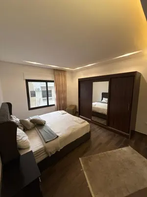 a bedroom with a large bed and a mirror at 3bedroom apart Deir Ghbar JRE in Amman