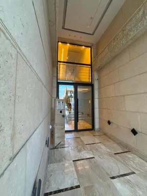 an empty hallway of a building with a glass door at 3bedroom apart Deir Ghbar JRE in Amman