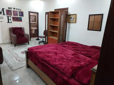 a bedroom with a red bed and a chair at Nice comfy room in Amman