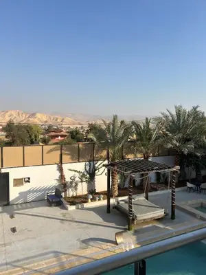 a view of a resort with a pool and palm trees at Eva chalet in Deadsea in Al Kafrayn