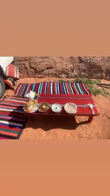 a table with plates of food on top at Rose Al Ghaith Camp in Disah