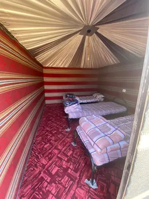 a small room with two beds in a tent at Rose Al Ghaith Camp in Disah