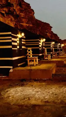 a group of chairs sitting outside of a building at night at Rose Al Ghaith Camp in Disah