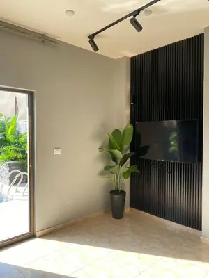 a plant in the corner of a room with a window at SAN VITO Chalet in Sowayma