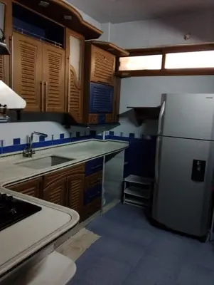 a kitchen with a white refrigerator and wooden cabinets at Coazmatic apartment in Kerak