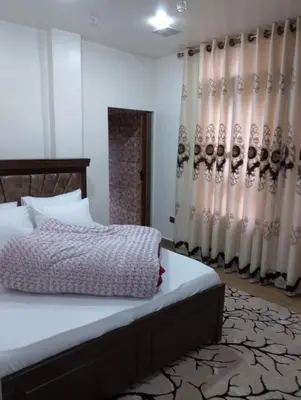 a bedroom with a bed and curtains in a room at Coazmatic apartment in Kerak