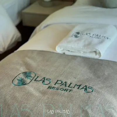 a bed with a us palms hospital towel on it at Las palmas resort in Sowayma