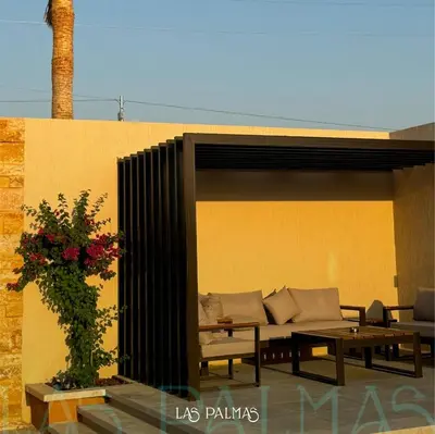a patio with a couch and a table at Las palmas resort in Sowayma