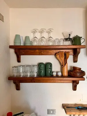 a wooden shelf with glasses and utensils on it at Amman Antique Penthouse in Amman