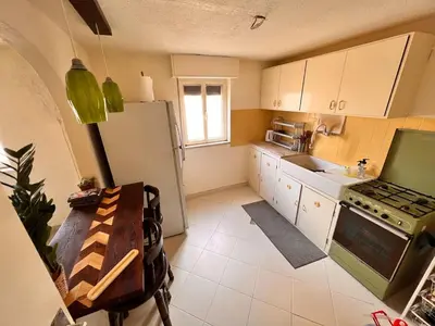a small kitchen with a refrigerator and a sink at Amman Antique Penthouse in Amman