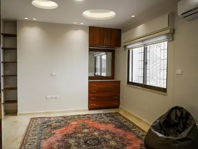 a living room with a dresser and a large rug at Yafa 2BR N Abdoun Apartment in Amman