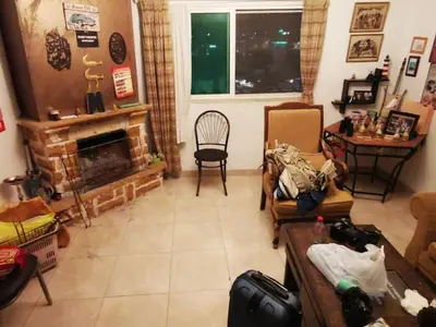 a living room with a fireplace and a chair at over theatre apartment in Amman