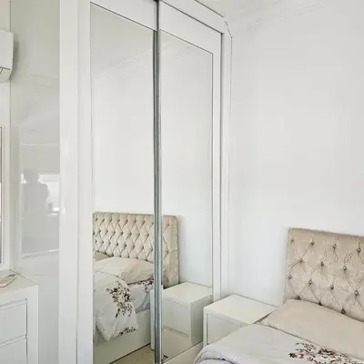 a bedroom with a mirror and a bed at Cozy apartment in Amman