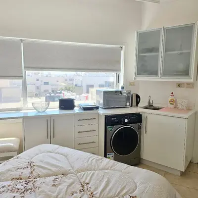a kitchen with a washing machine and a window at Cozy apartment in Amman