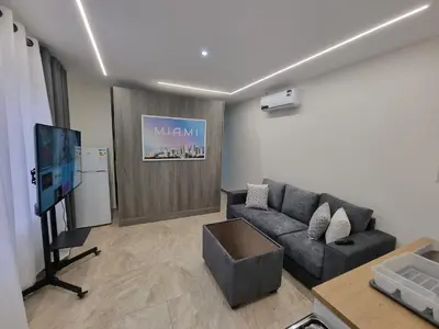 a living room with a couch and a flat screen tv at Sama Dier Ghbar 1 in Amman