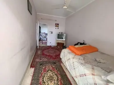 a small bedroom with a bed and a rug at Zarmot INN in Az Zarqa