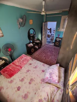 a bedroom with a bed with pink sheets at Zarmot INN in Az Zarqa