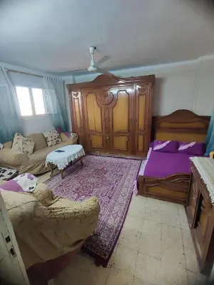 a living room with a bed and a couch at Zarmot INN in Az Zarqa