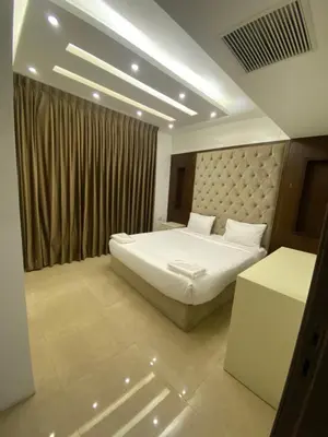 a bedroom with a white bed and a curtain at abdoun rooftop 1bedroom kh&sh 04 in Amman