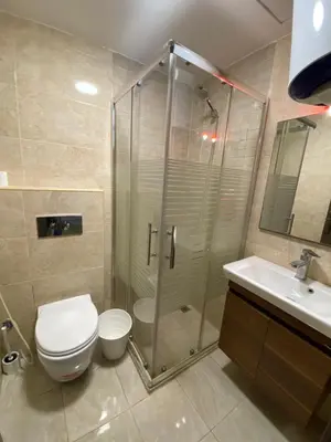 a bathroom with a shower and a toilet and a sink at abdoun rooftop 1bedroom kh&sh 04 in Amman
