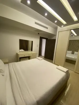 a large white bed in a room with a mirror at abdoun rooftop 1bedroom kh&sh 04 in Amman