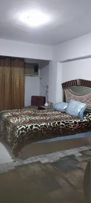 a bedroom with a bed with a cheetah blanket at Nassen House in Udhruḩ