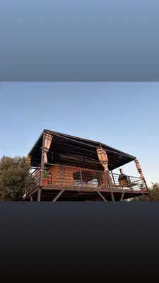 a building with a dog sitting on a balcony at Olive house in Um Qeis