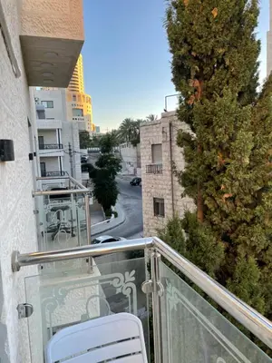 a balcony with a chair and a christmas tree at Sawa Apartment in Amman