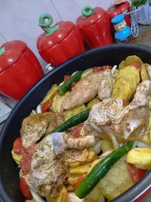 a pan filled with meat and vegetables with peppers at Poster apartment in Maḩaţţat Jurf ad Darāwīsh