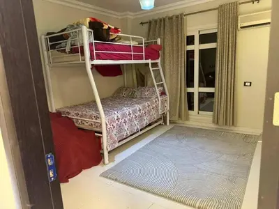 a bedroom with bunk beds with a dog sitting on top at Poster apartment in Maḩaţţat Jurf ad Darāwīsh