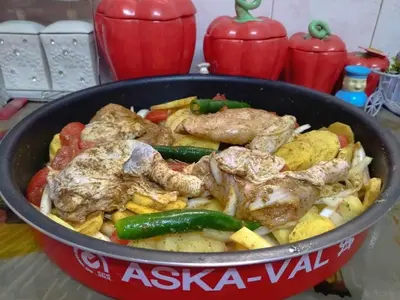 a pan filled with meat and vegetables on a table at Poster apartment in Maḩaţţat Jurf ad Darāwīsh