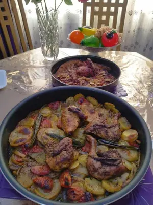 a table with two pans of food on a table at Poster apartment in Maḩaţţat Jurf ad Darāwīsh