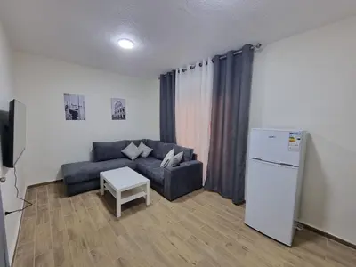 a living room with a couch and a refrigerator at Sama Dier Ghbar 3 in Amman