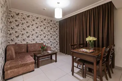 a living room with a couch and a table at Lancaster Hotel Apartments-Gardens in Amman