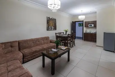 a living room with a couch and a table at Lancaster Hotel Apartments-Gardens in Amman