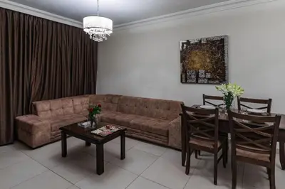 a living room with a couch and a table at Lancaster Hotel Apartments-Gardens in Amman