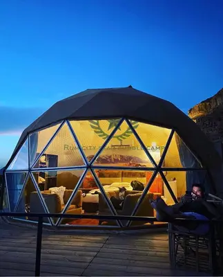 a man is sitting in a glass igloo at RUM CITY STAR BUBBLE lUXURY CAMP in Wadi Rum
